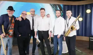 Zespół Mr. Zoob gotowy do występu. Muzycy w białych koszulach i jeansach, jeden z gitarą, drugi z saksofonem. "Mój jest ten kawałek podłogi" - tekst piosenki.