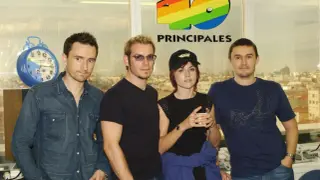 The Cranberries, marząc o sukcesie, pozują przed logo 40 Principales.