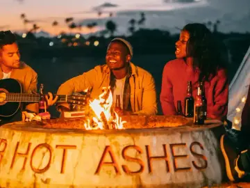 Wszyscy byliśmy harcerzami, gdy płonie ognisko. Tekst na kamieniu "HOT ASHES" przypomina o dawnych czasach.