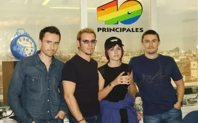 The Cranberries, marząc o sukcesie, pozują przed logo 40 Principales.