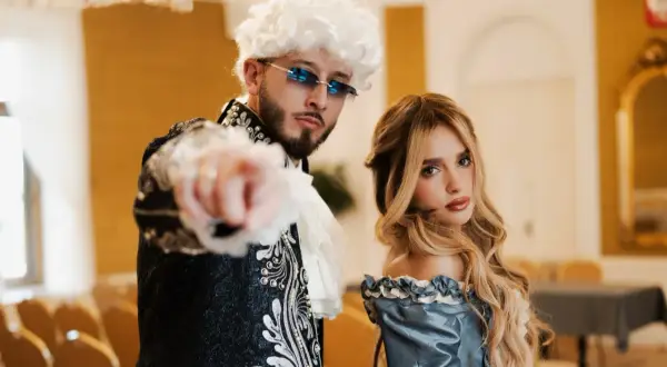 Para z epoki, on w peruce i okularach, ona w błękitnej sukni. Ich styl to akcent mandacik tekst.