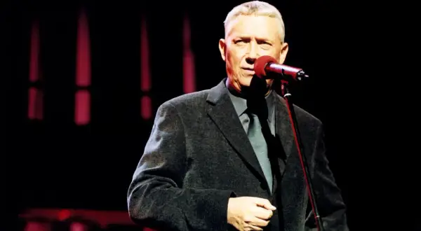 Wojciech Młynarski śpiewa "Nie ma jak u mamy" na scenie.