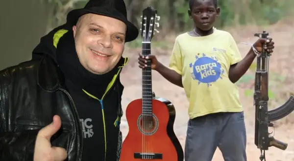 Mężczyzna w czarnym kapeluszu i chustce daje kciuk w górę. Obok chłopiec z gitarą i karabinem. Makumba tekst.
