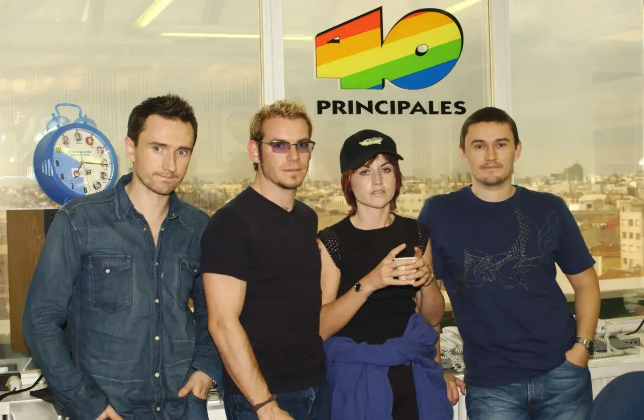 The Cranberries, marząc o sukcesie, pozują przed logo 40 Principales.