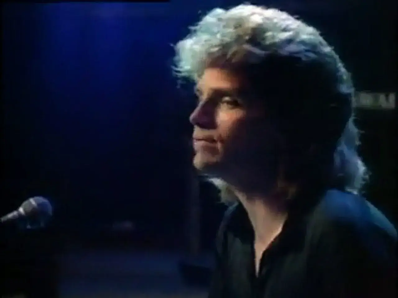 Richard Marx, z charakterystyczną fryzurą, śpiewa